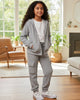 Young girl in a gray pinstripe outfit standing in a living room.