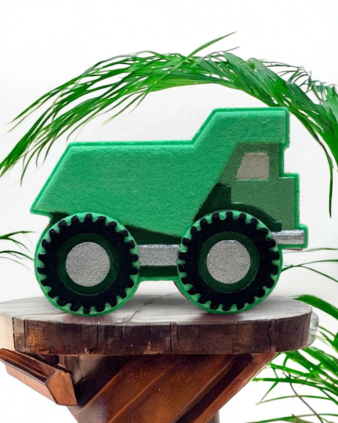 Calla Lily Cosmetics + CL kids green dump truck bath bomb with citrus scent on a wooden stand