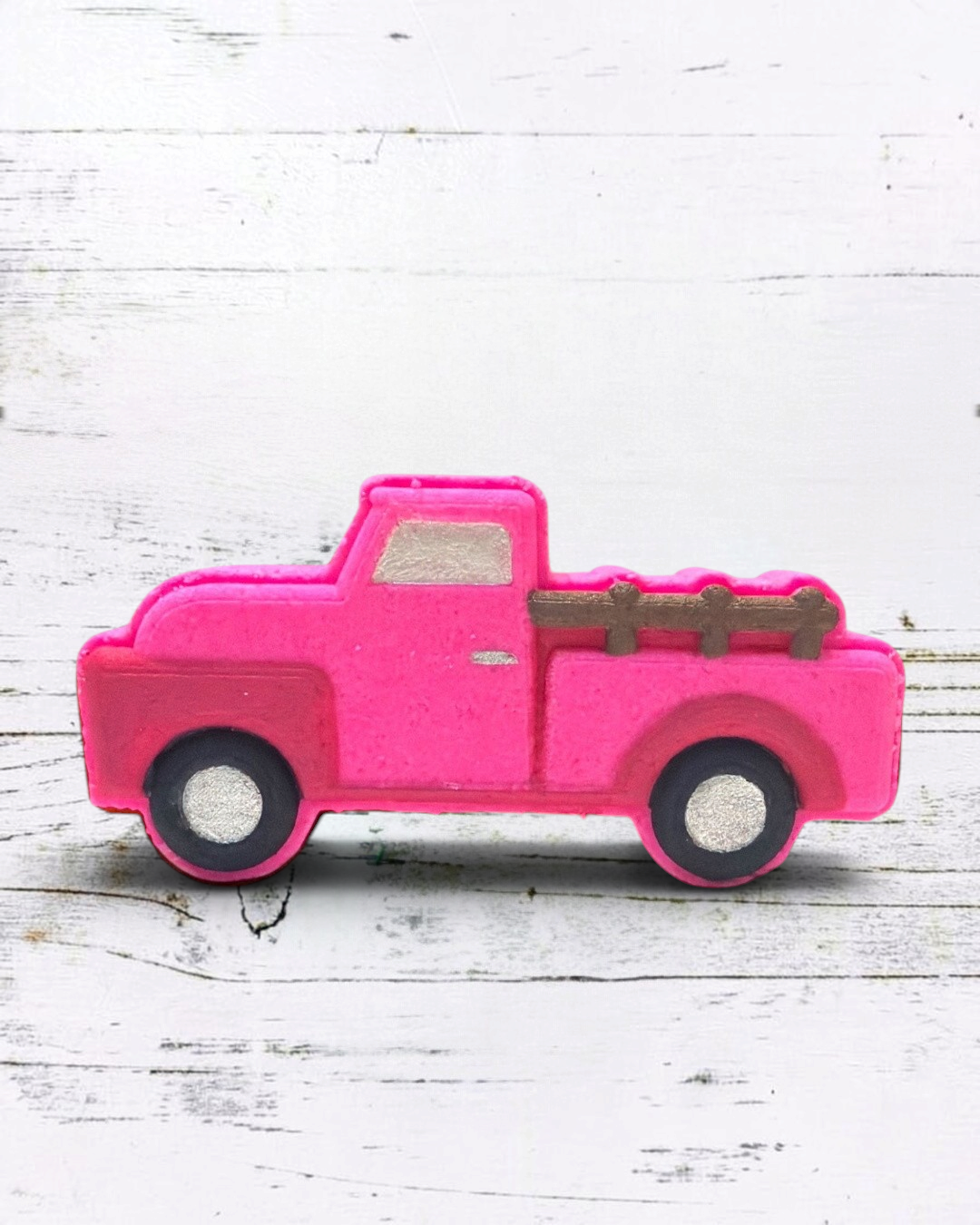 Calla Lily Cosmetics + CL kids pink vintage truck bath bomb with strawberry scent on a white wooden background