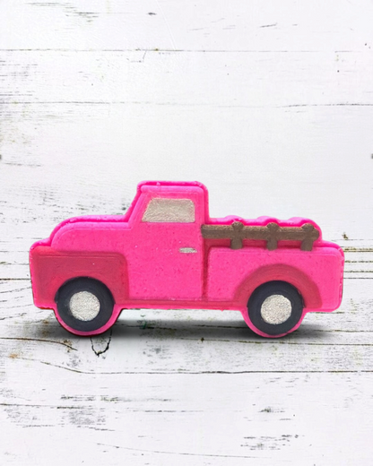 Calla Lily Cosmetics + CL kids pink vintage truck bath bomb with strawberry scent on a white wooden background