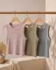 Three striped tank tops hanging on a rack against a neutral background