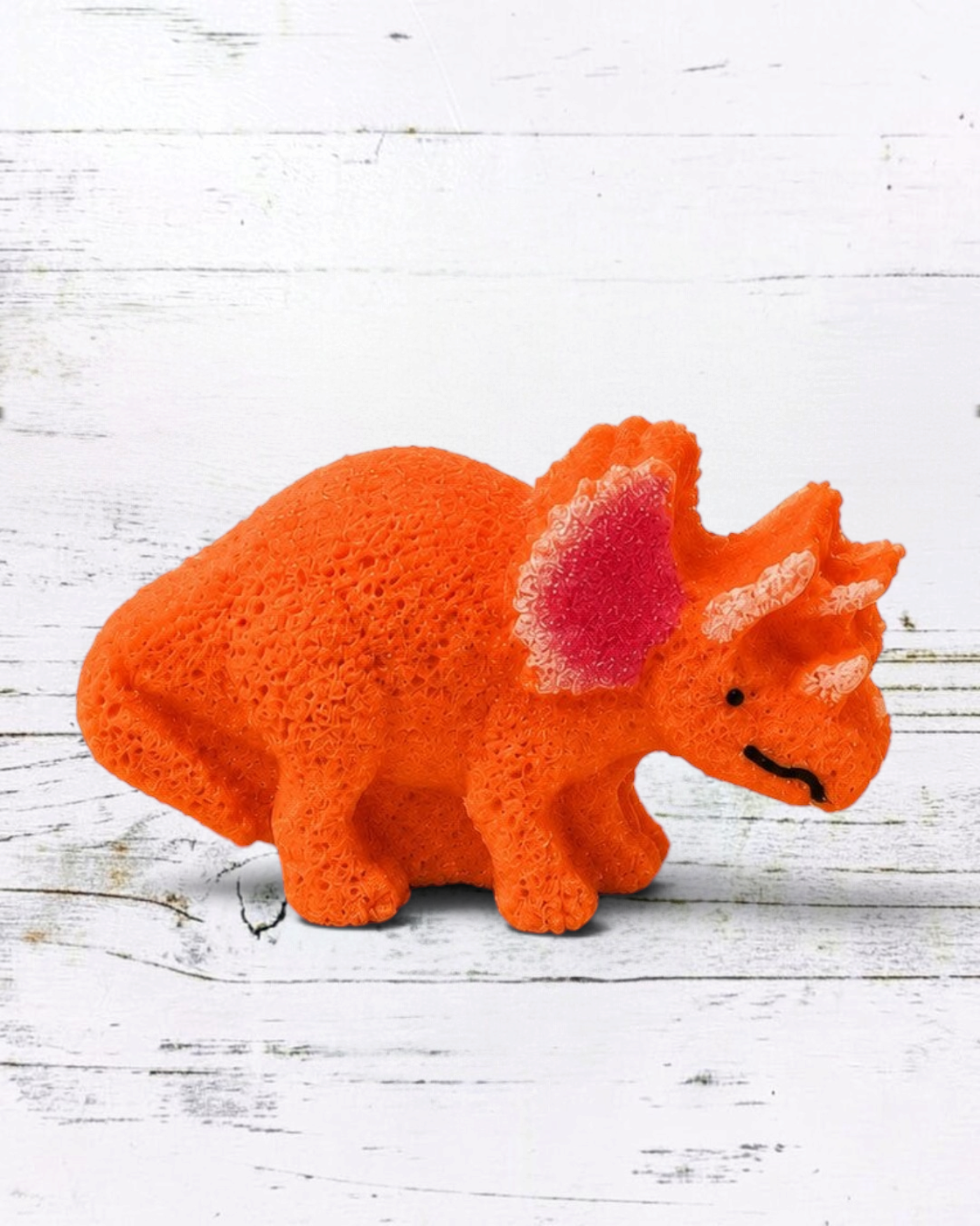 Calla Lily Cosmetics + CL kids orange Triceratops dinosaur bath bomb with coconut oil and cocoa butter on a tray.