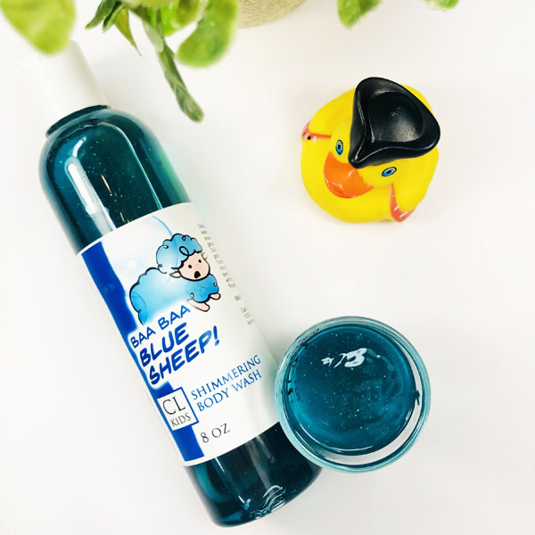 A transparent bottle and cup of our blue sheep body wash against a white background