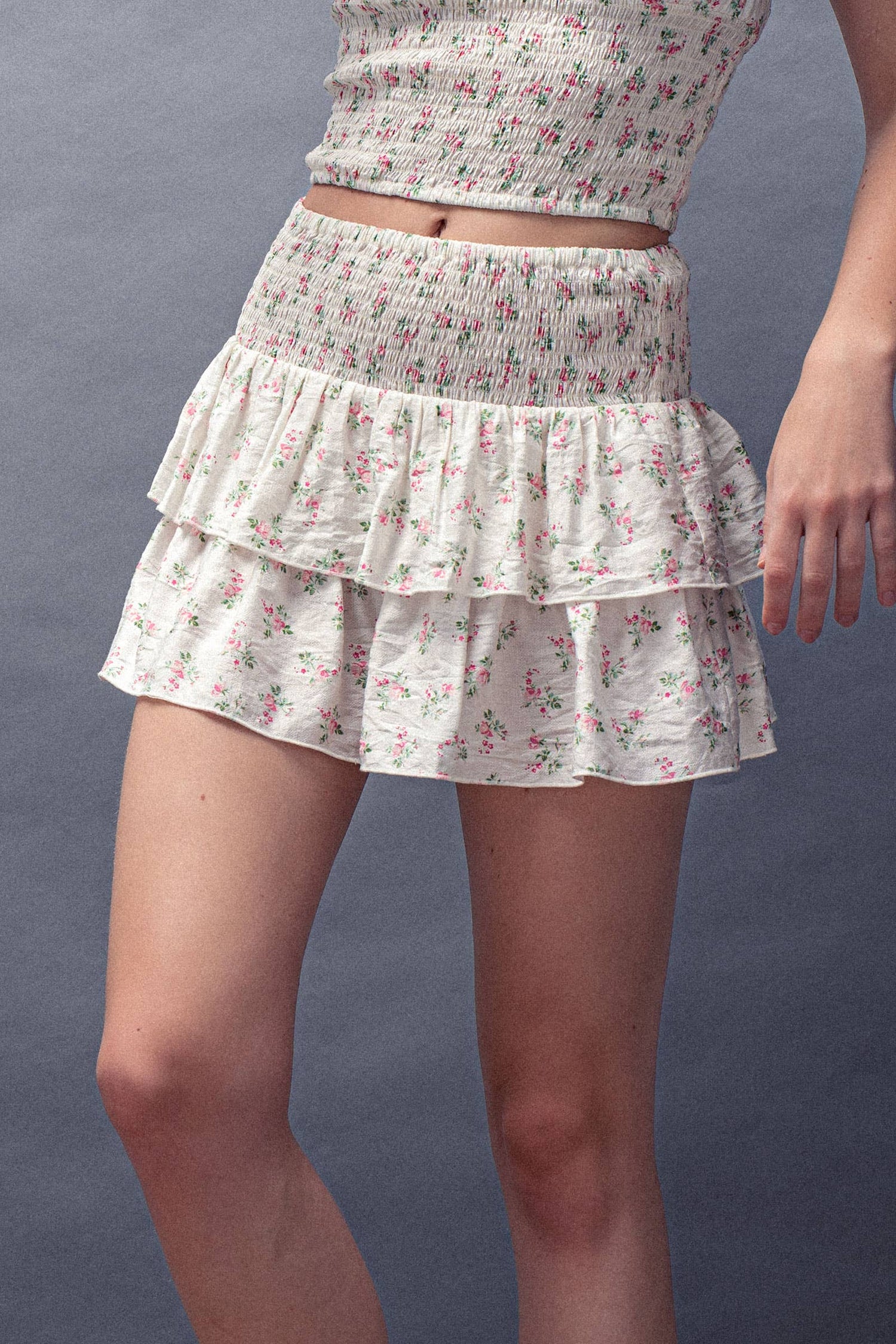 Floral tiered skirt worn by a person on a plain background