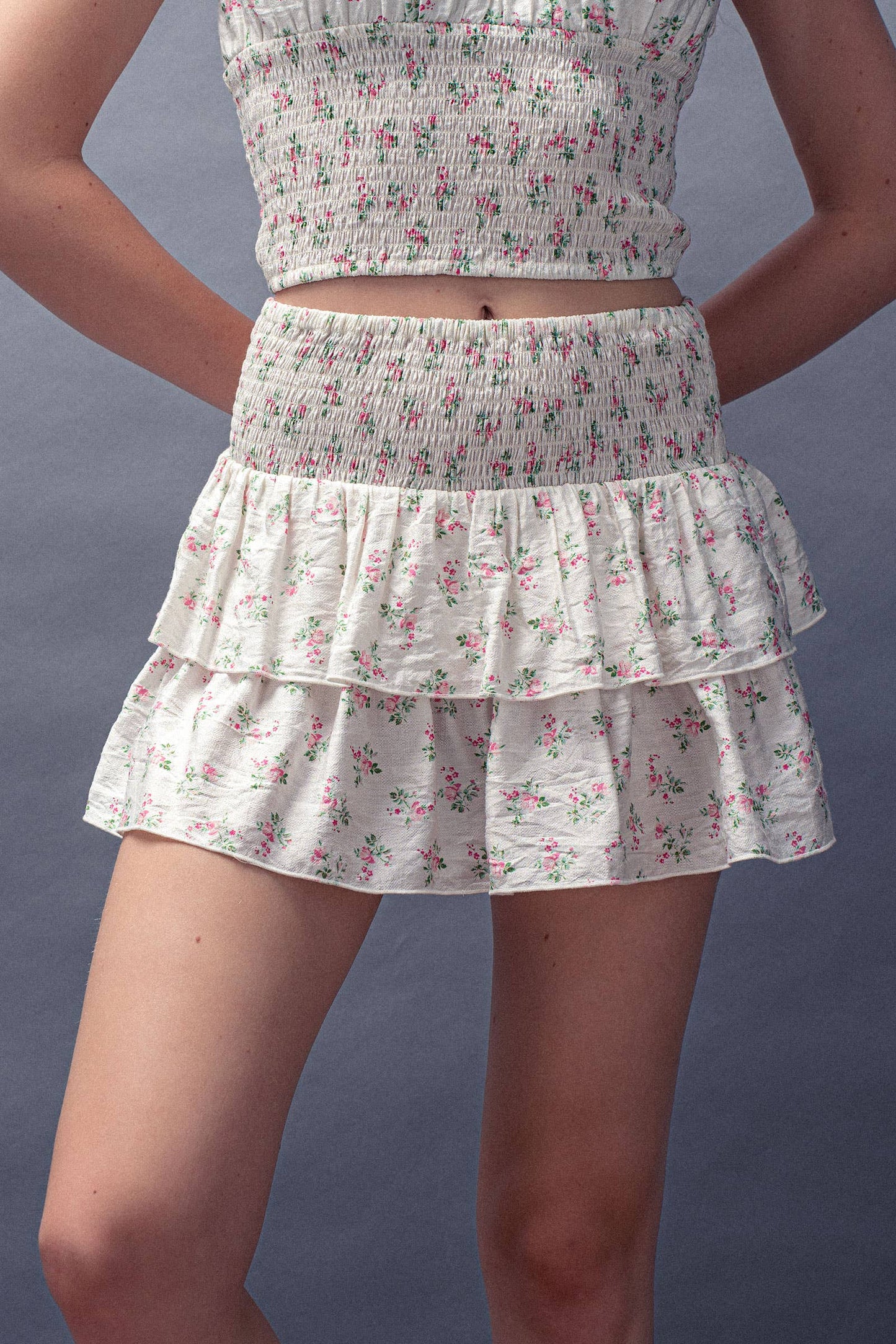 Floral tiered skirt worn by a person on a plain background