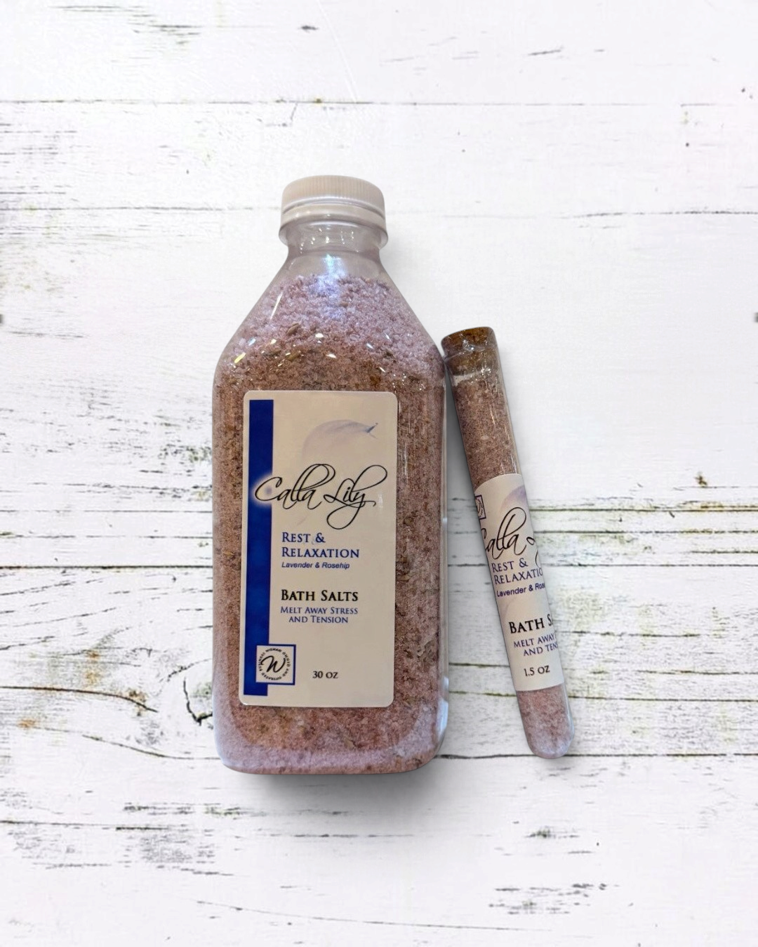 Bottle and stick of bath salts with a label on a white background