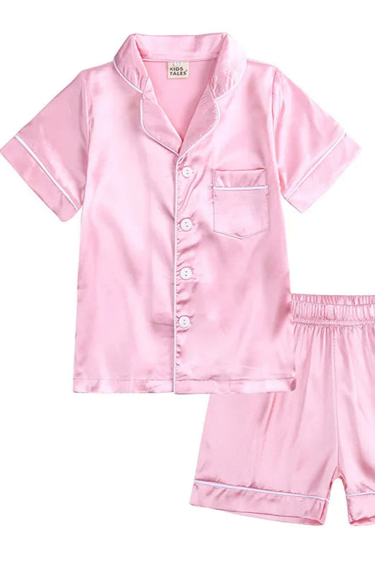 Pink satin pajama set with shirt and shorts on a white background