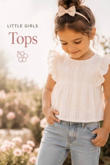 Young girl wearing a white top and blue jeans with a blurred floral background