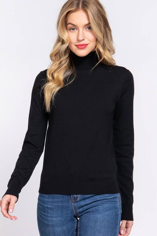 Woman wearing a black turtleneck sweater and blue jeans on a white background
