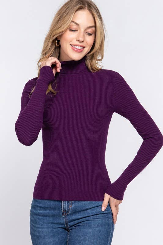Woman wearing a purple turtleneck sweater and blue jeans on a white background
