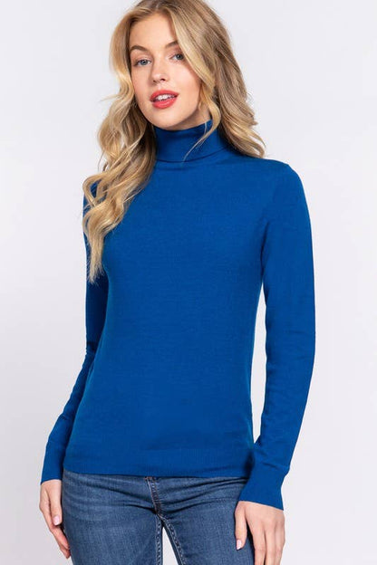 Woman wearing a blue turtleneck sweater against a white background