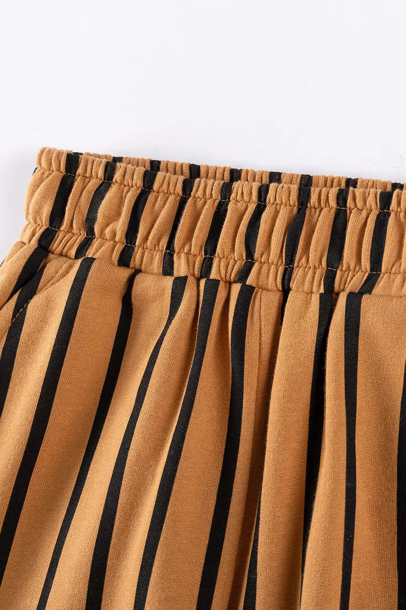 Close-up of brown pants with black stripes on a white background