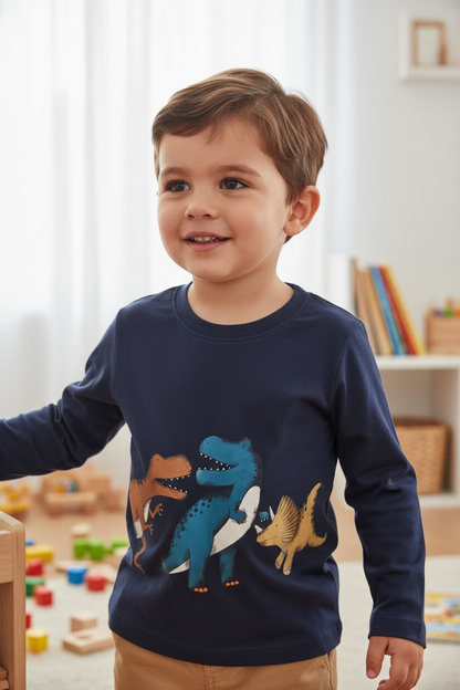 Child wearing a navy blue sweater with dinosaur designs in a room with toys and books.