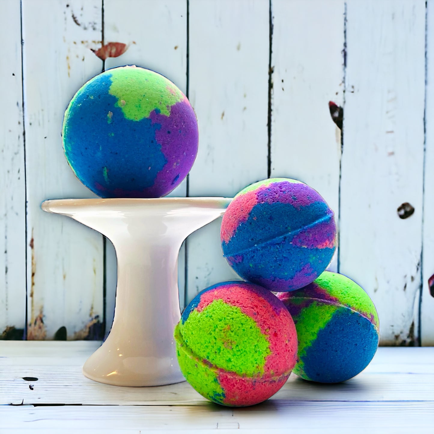 Colorful bath bombs on a white stand against a rustic wooden background