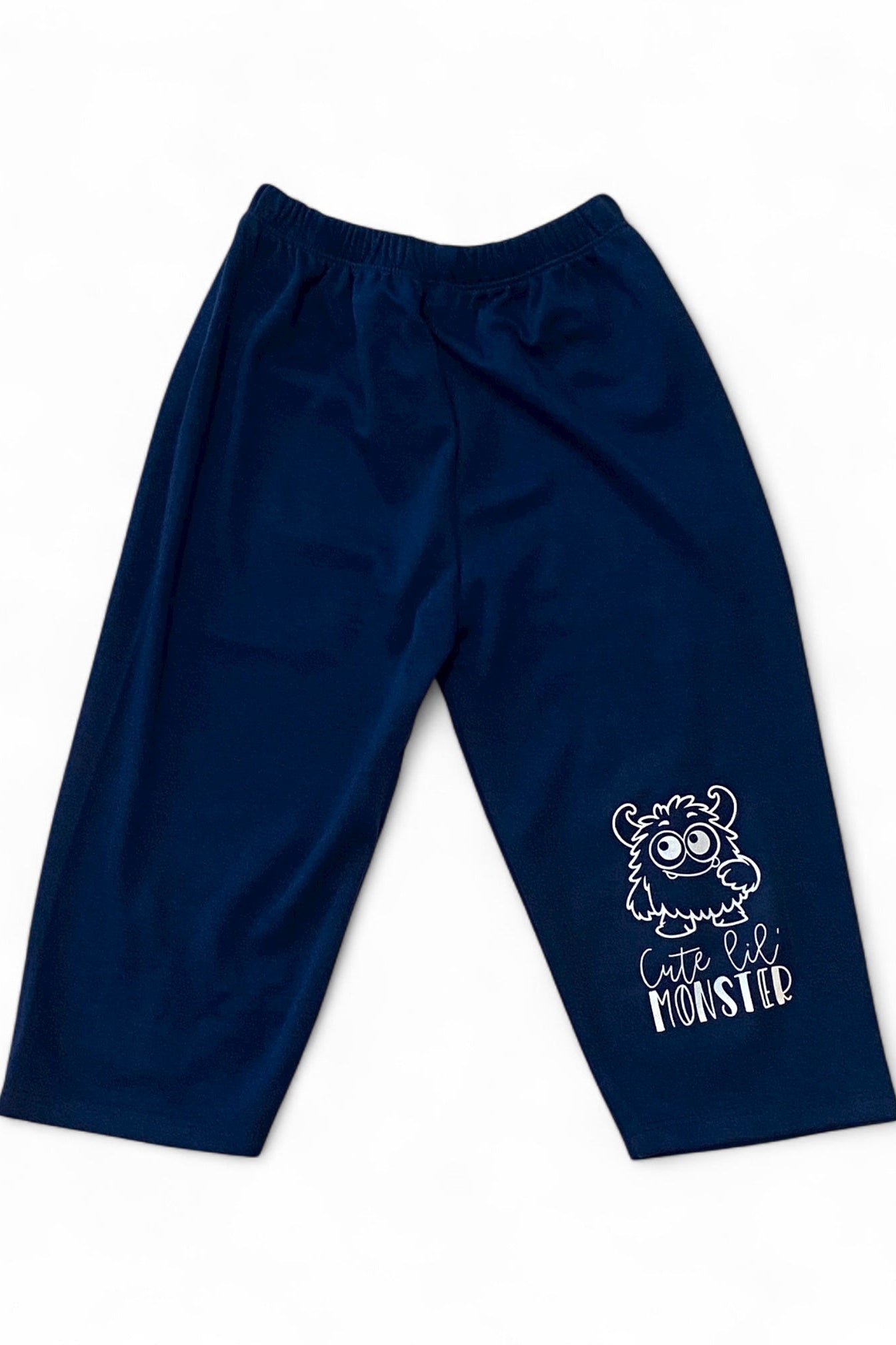 Navy blue pants with a cartoon monster design on a white background