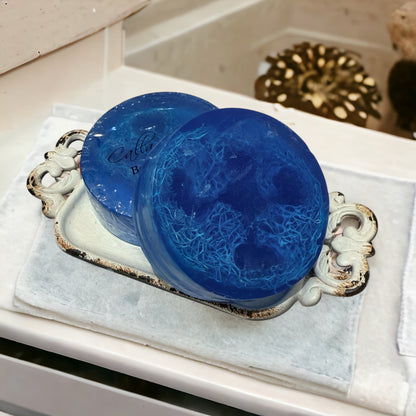 Two blue soaps on a decorative tray with a blurred background