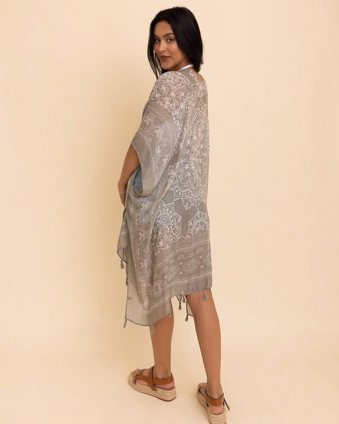 Woman wearing a patterned dress against a beige background