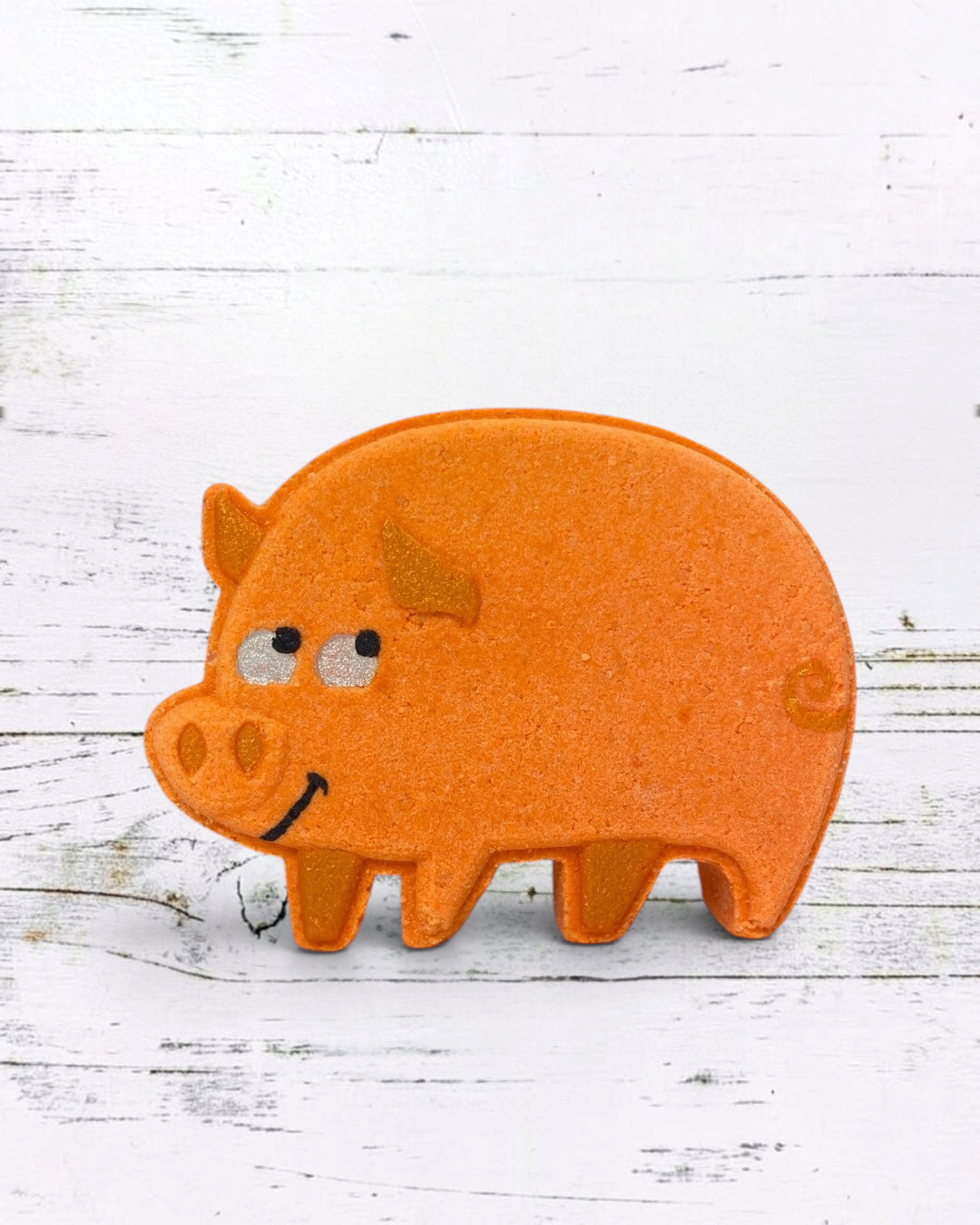 Orange pig-shaped object on a white wooden surface
