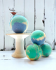 Calla Lily Cosmetics + CL kids Ocean Water bath bombs with blue and green swirls on a white pedestal