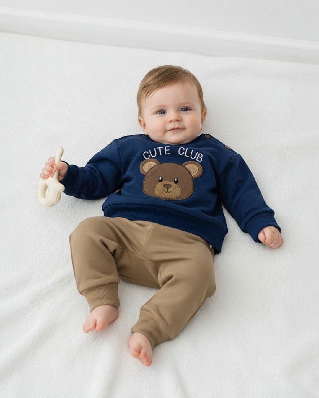 Children's navy sweatshirt with bear design and brown pants on a white background