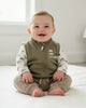 Children's outfit with green vest, patterned shirt, and brown pants on a white background
