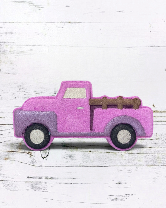 Calla Lily Cosmetics + CL kids purple vintage truck bath bomb with grape soda scent on a white wooden background