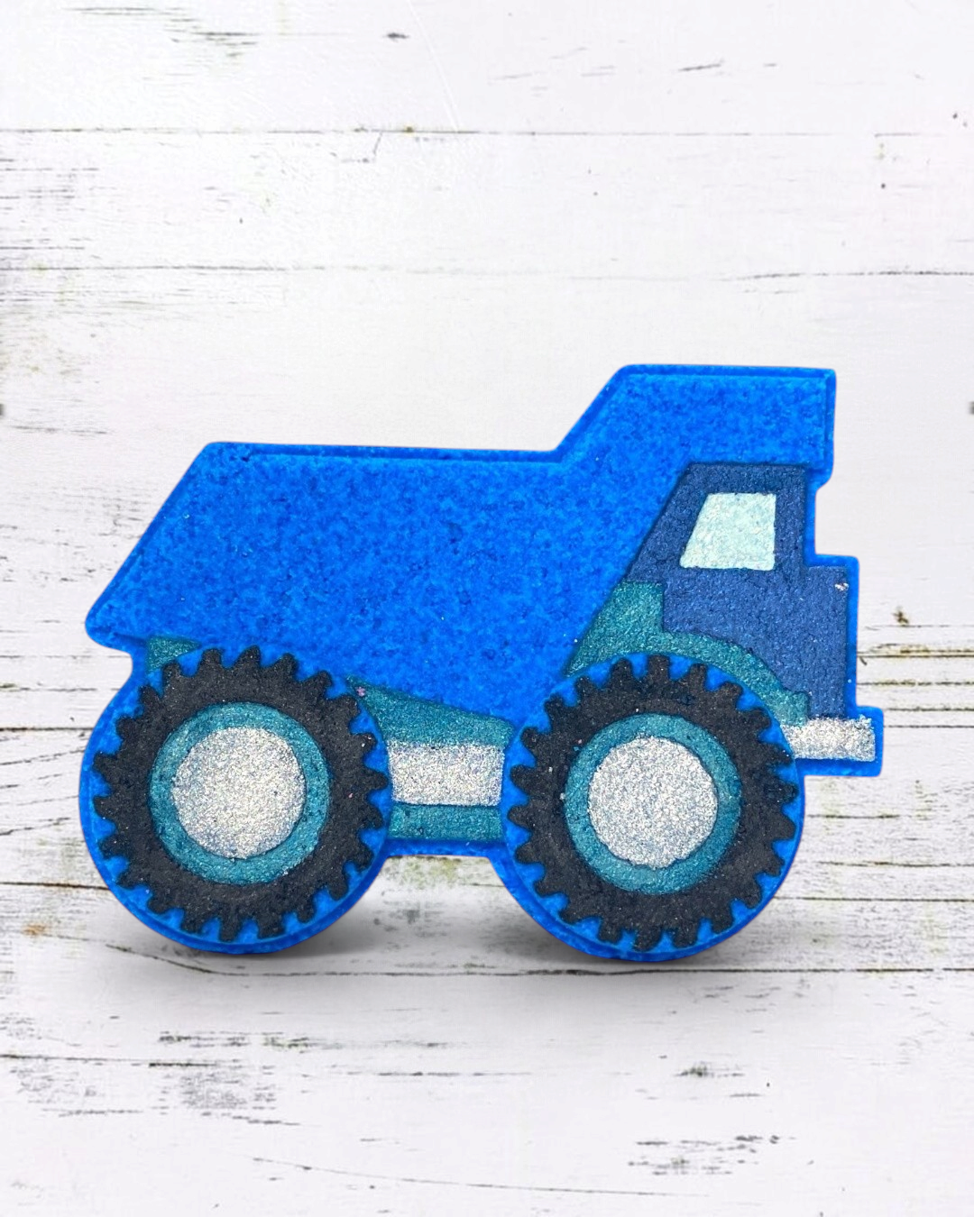 Calla Lily Cosmetics + CL kids blue dump truck shaped bath bomb with blueberry scent and glittery wheel details.