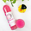 Piggy Snorts Shimmering Body Wash in a transparent bottle and cup of our pink piggy snorts body wash against a white background