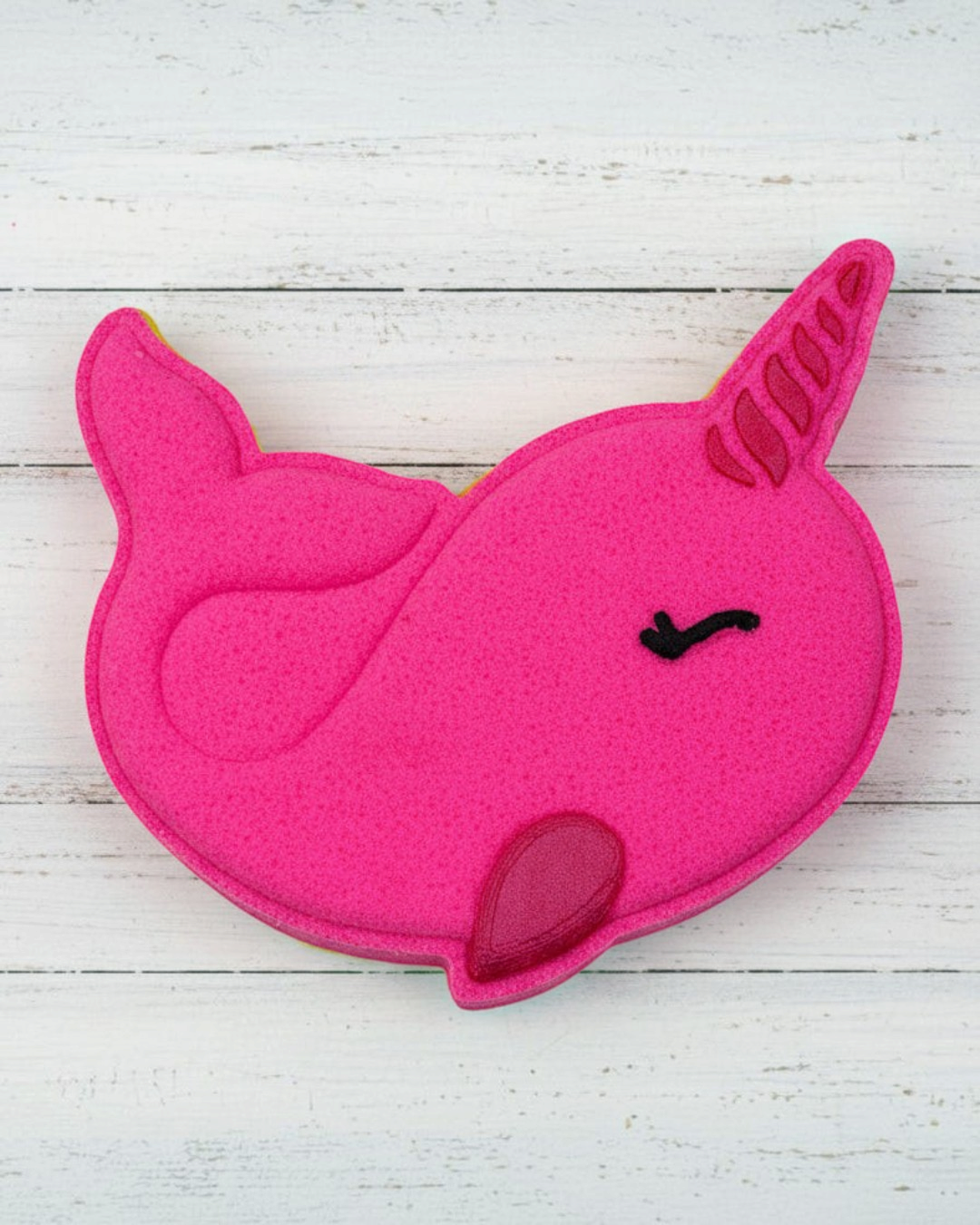Pink unicorn-shaped object on pebbles