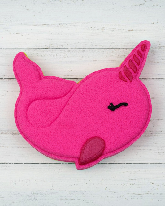 Pink unicorn-shaped object on pebbles