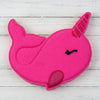 Pink unicorn-shaped object on pebbles