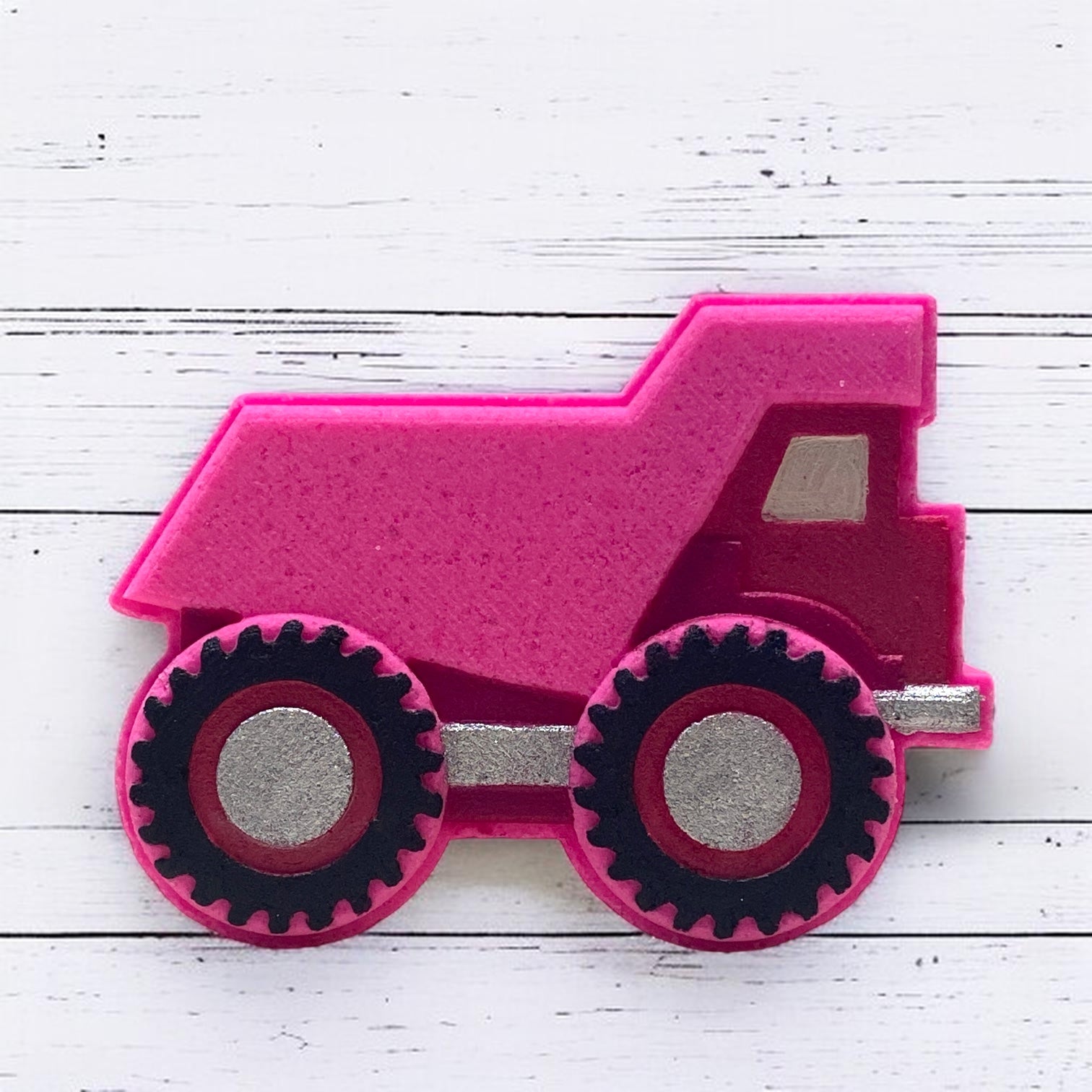 Pink bath bomb dump truck on a white wooden surface