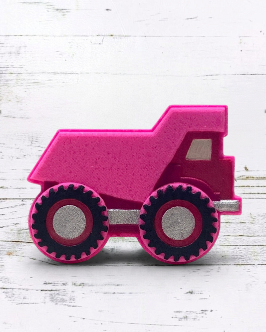 Pink bath bomb dump truck on a white wooden surface