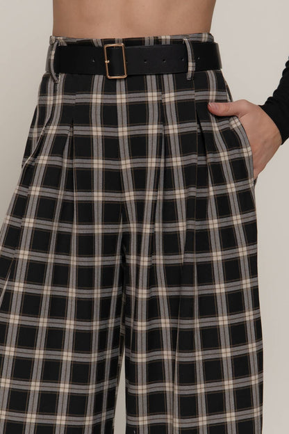 Black and white plaid pants with a belt on a plain background