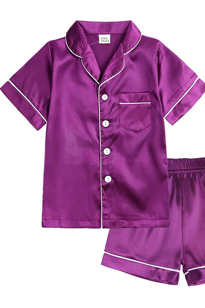 Purple satin pajama set with white buttons and trim on a white background