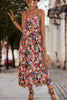 Woman wearing a colorful floral dress on a street.