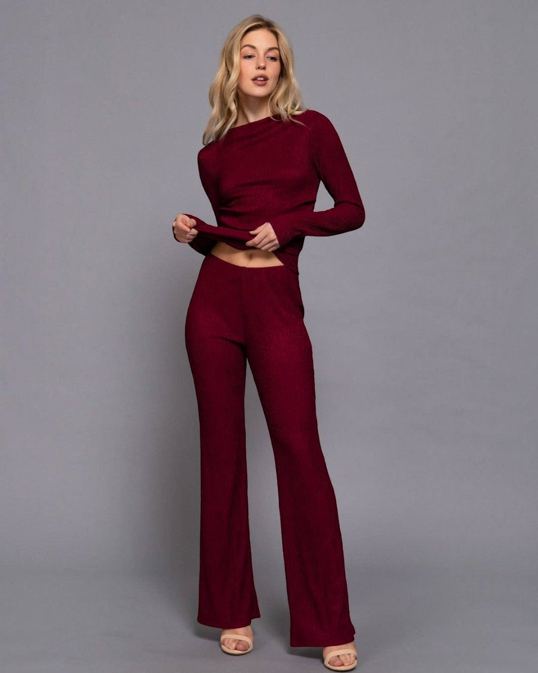 Woman wearing a burgundy outfit against a gray background
