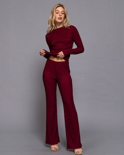 Woman wearing a burgundy outfit against a gray background