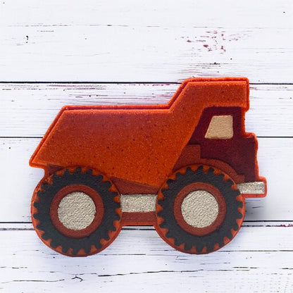 Red bath bomb dump truck on a white wooden surface