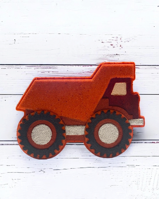 Red bath bomb dump truck on a white wooden surface