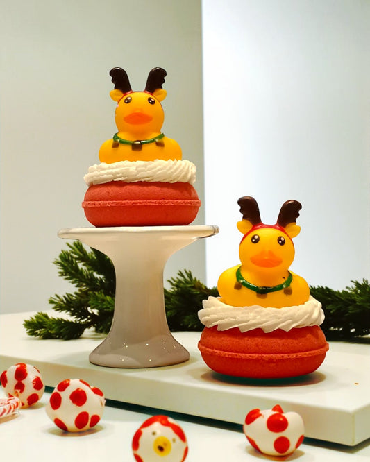 Two decorative duck figurines with antlers on a stand with a plain background