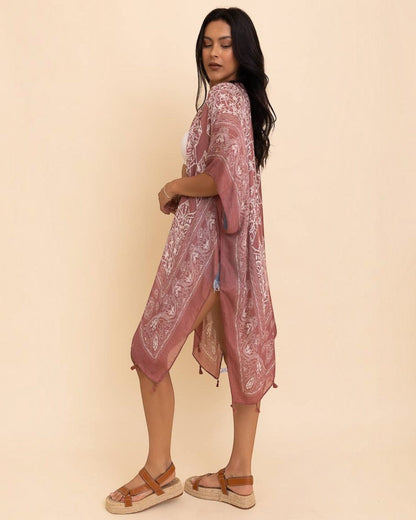 Woman wearing a pink lace dress against a beige background