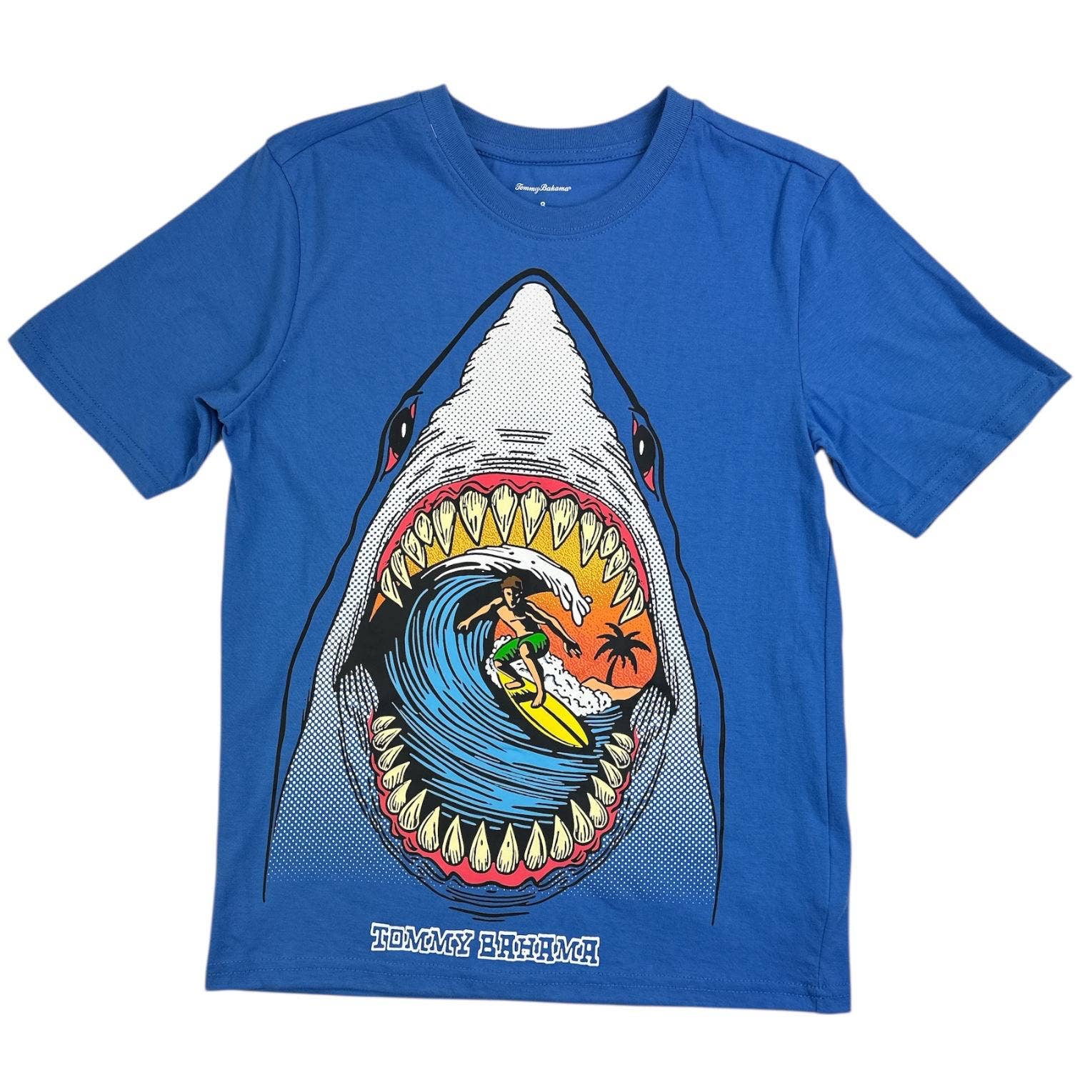 Blue t-shirt with a shark graphic featuring a surfer, on a white background