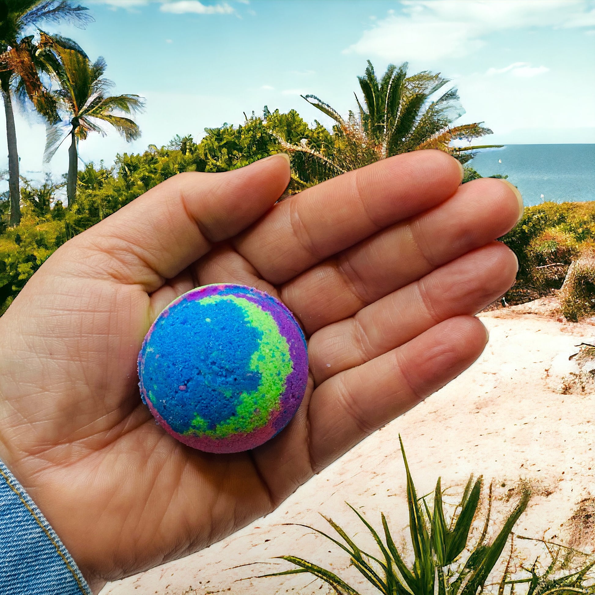 Colorful bath bomb held in a hand with a tropical background