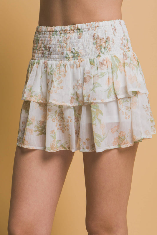 Floral tiered skirt worn by a person on a beige background