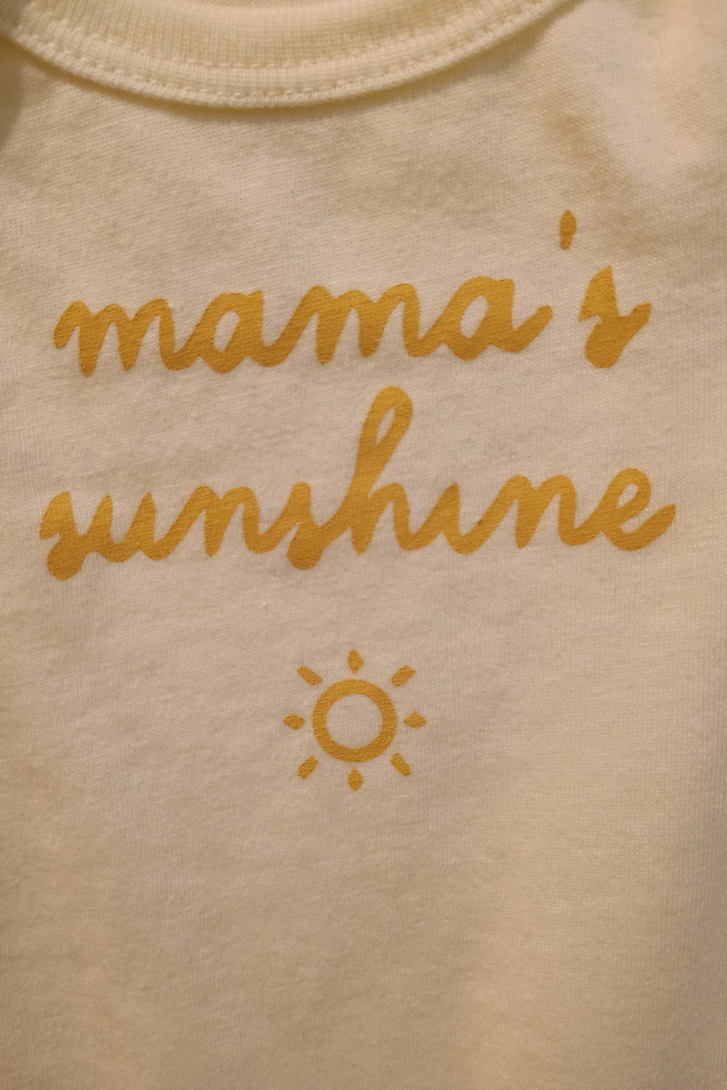 Light yellow fabric with 'mama's sunshine' text and sun symbol in yellow.
