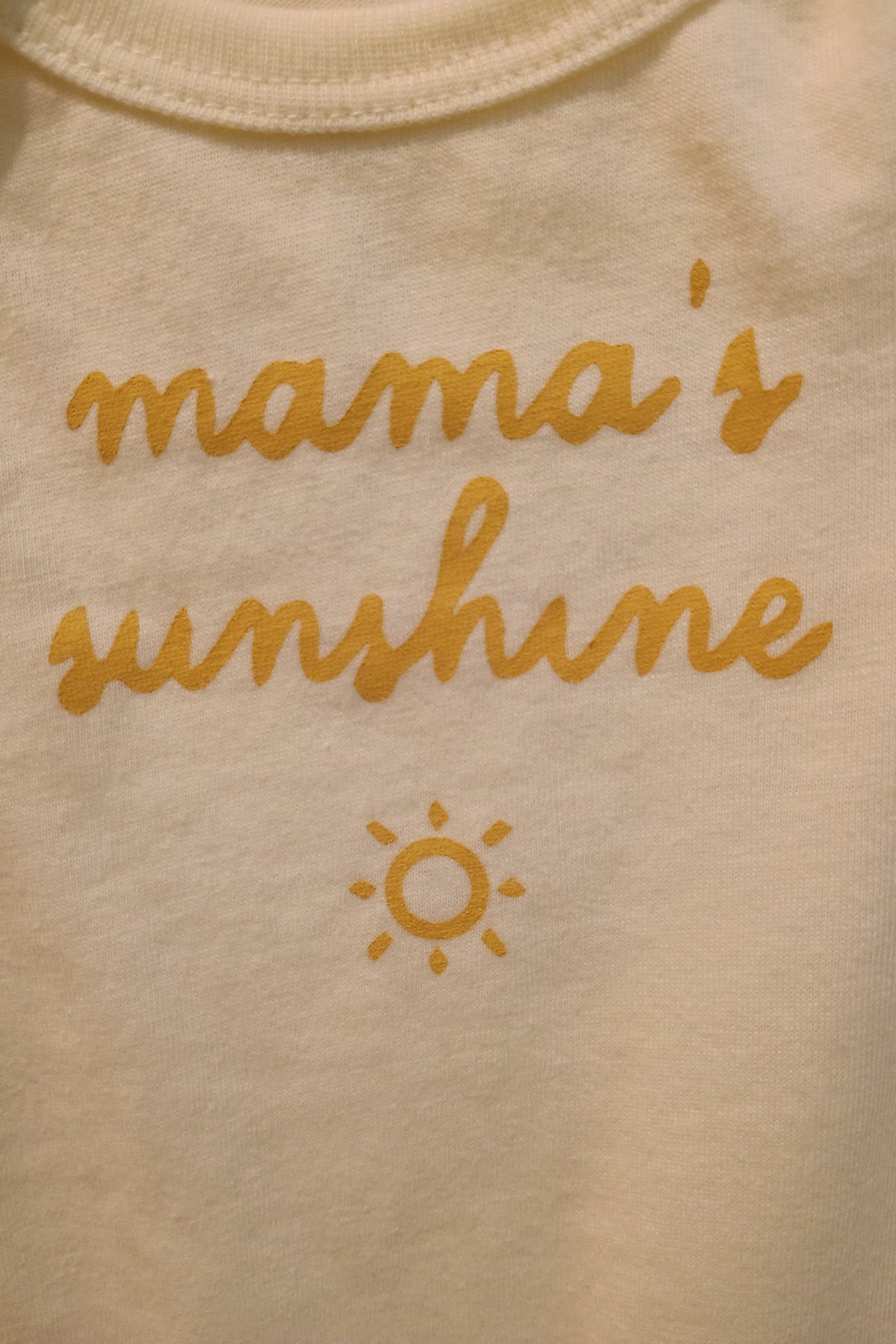 Light yellow fabric with 'mama's sunshine' text and sun symbol in yellow.