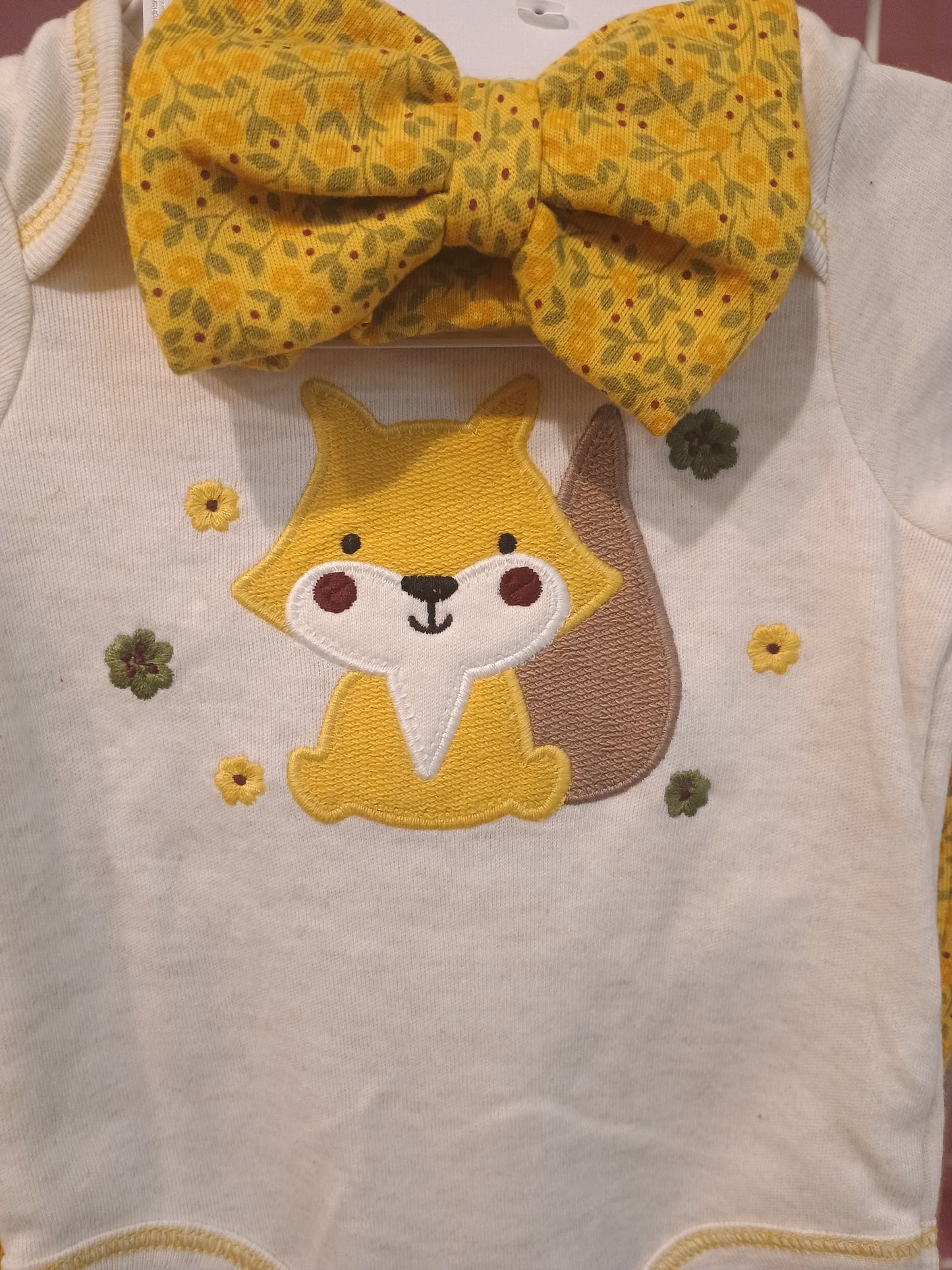 Yellow headband with floral pattern and embroidered fox on a white fabric background