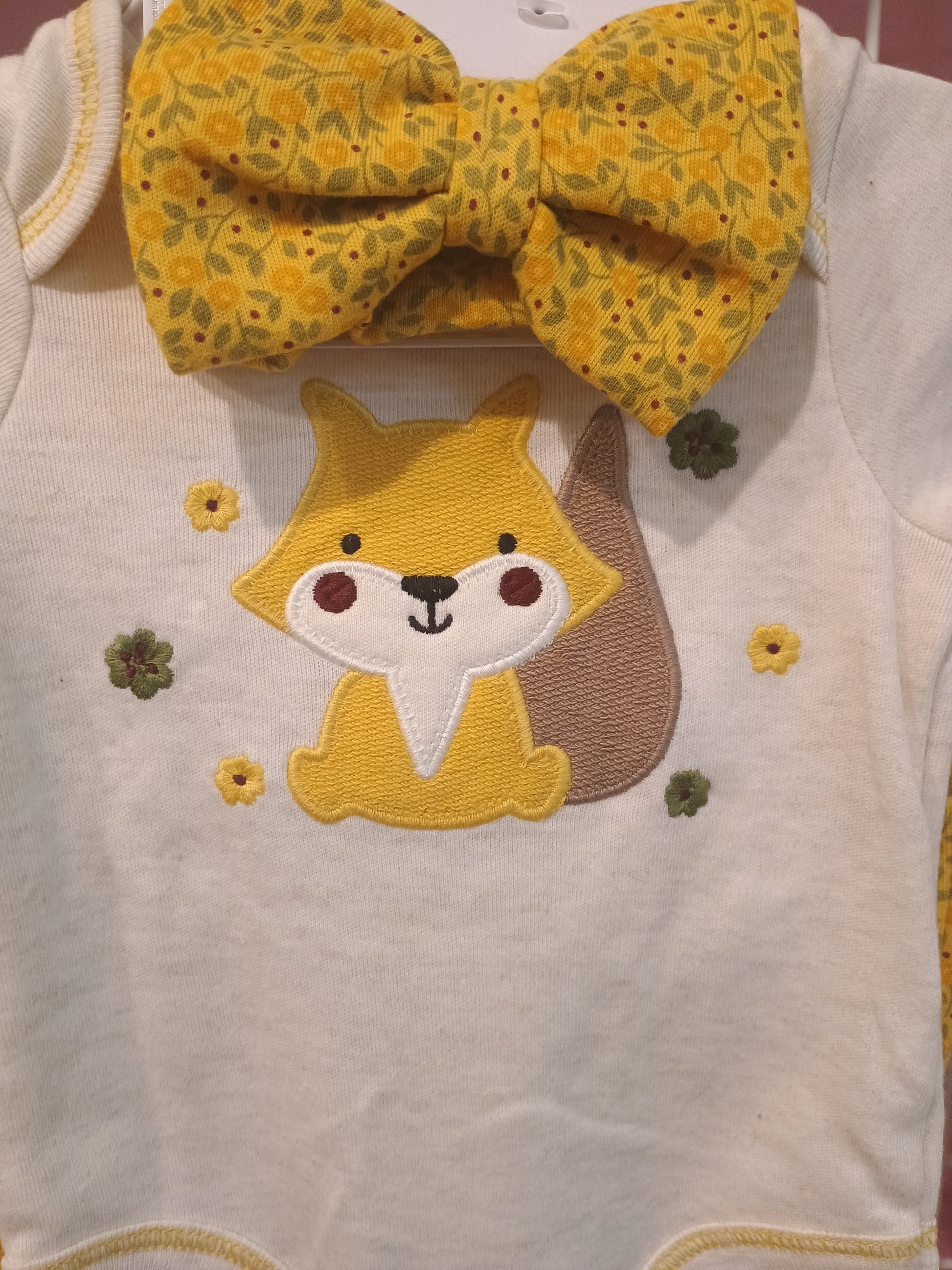 Yellow headband with floral pattern and embroidered fox on a white fabric background