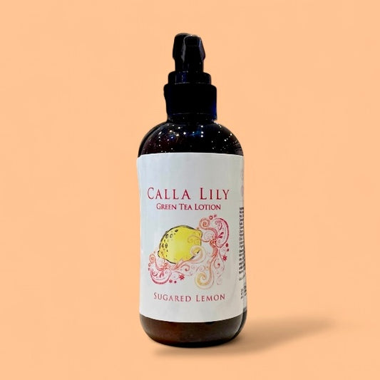 Bottle of Calla Lily Green Tea Lotion with a lemon illustration on a beige background
